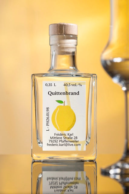Der Quittenbrand 1998 der Brennerei Karl abgebildet mit einem Glas und vor einem warmen Hintergrund.